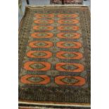 Pakistan rug of Turkoman design with two rows of eight gols on rust ground