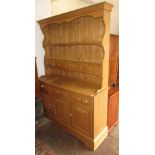 Reproduction pine dresser with a boarded shelf back above drawers and cupboards