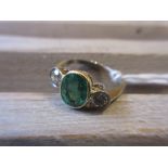 Platinum ring set oval emerald flanked by two brilliant cut diamonds