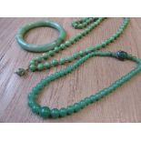 Early 20th Century mutton fat jade bead necklace together with a jade bangle and a glass bead