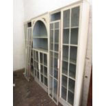 20th Century white painted breakfront bookcase, the central section with arched shelved top above