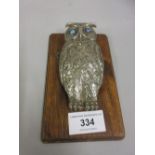 Novelty paper clip in the form of a silver plated owl with blue eyes, on oak plaque (missing spring)