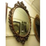 Reproduction mahogany carved and pierced oval wall mirror with bevelled plate