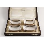 AN EARLY 20T CENTURY CASED SET OF FOUR SALTS with a hammered finish, of "dished" rectangular form on