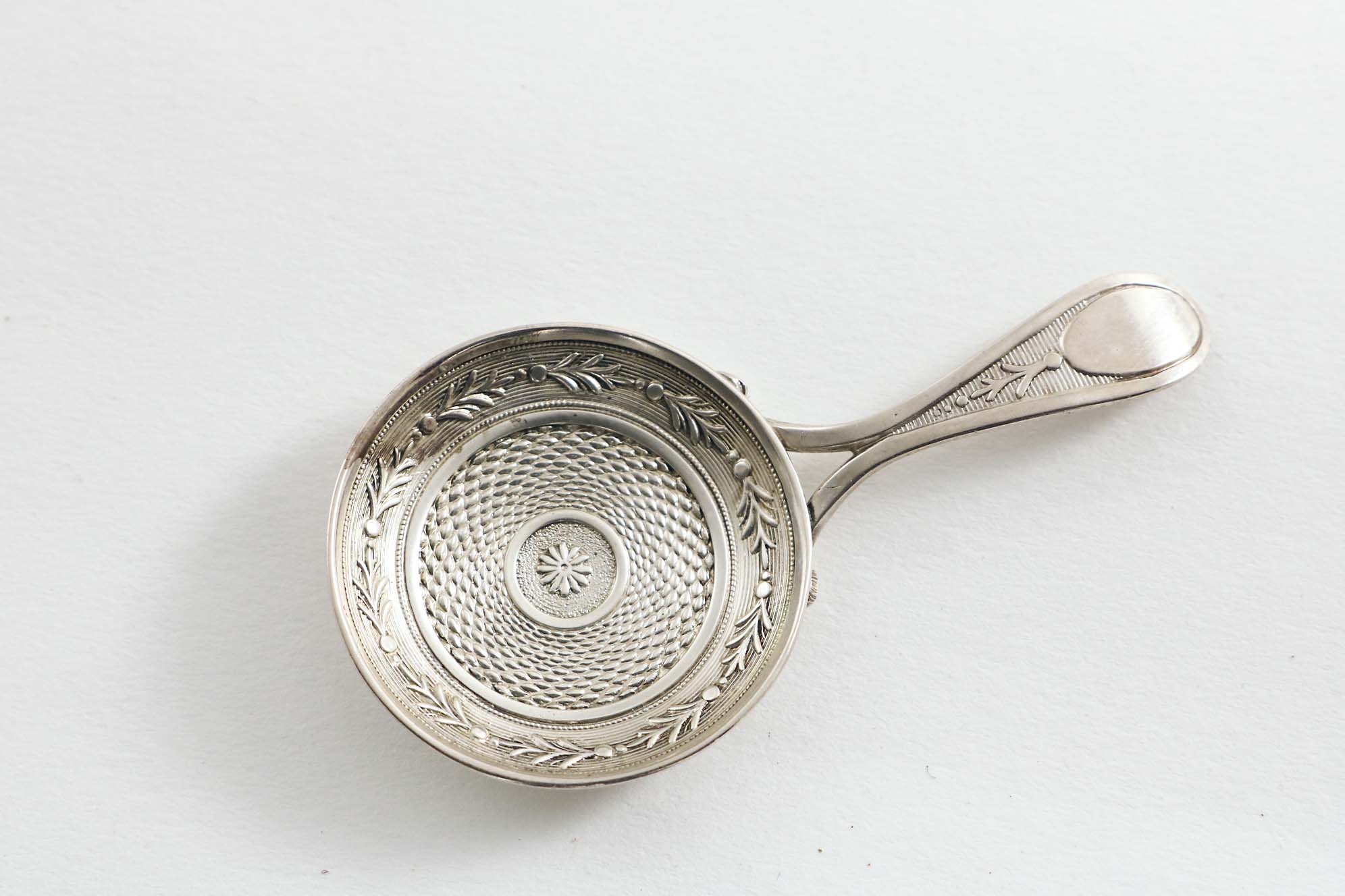 A GEORGE III "STAMPED" CADDY SPOON with a bifurcated handle & resembling a shallow frying pan, by