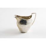 A GEORGE III SMALL ENGRAVED CREAM JUG with reeded borders, an angular handle and two vacant "