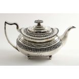 A GEORGE III TEA POT of rounded oblong form on ball feet, decorated with moulded ovolo borders and a