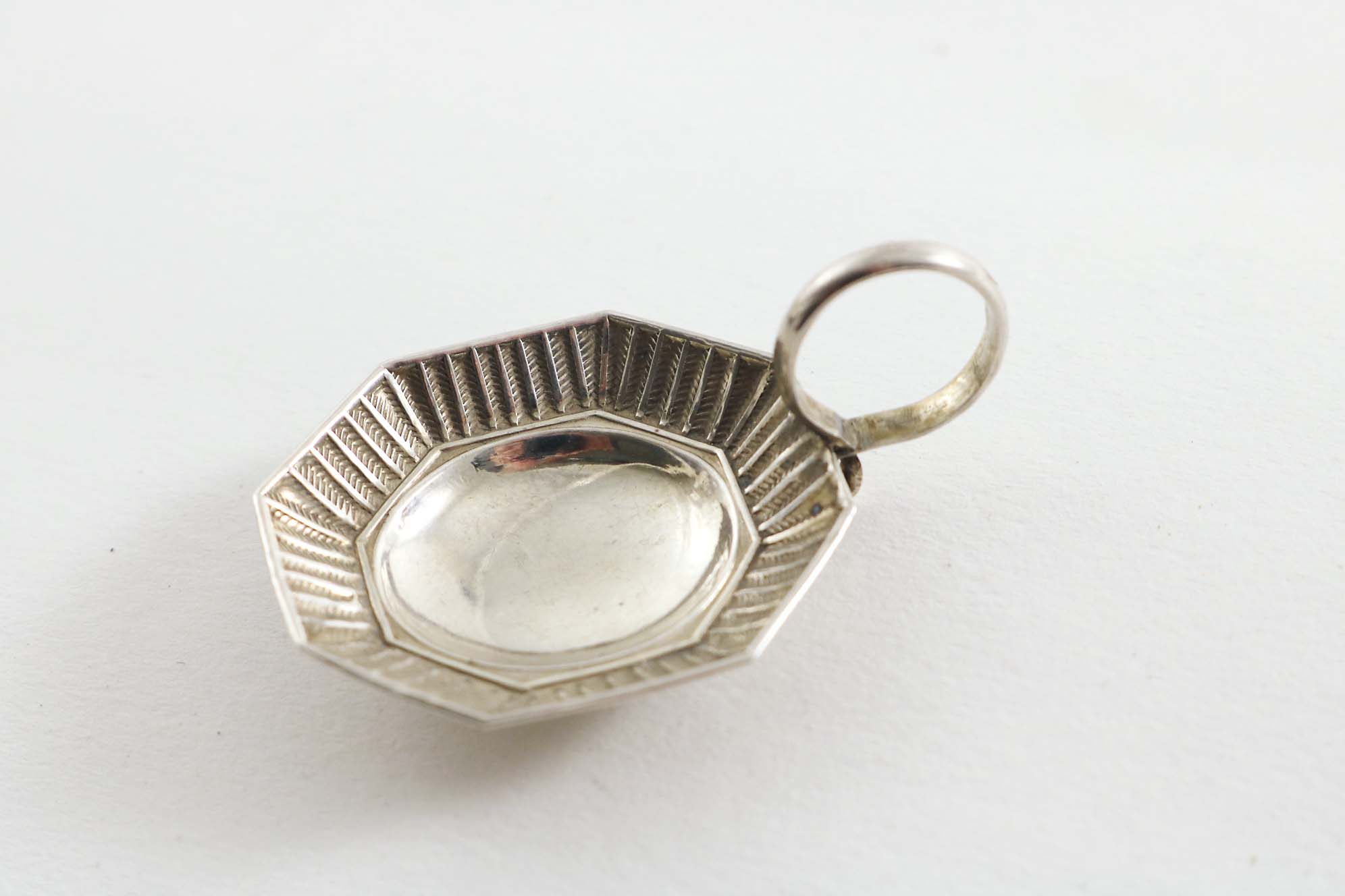 A GEORGE III CADDY SPOON with a ring handle and a small octagonal bowl with a stamped chevron