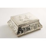 AN EDWARDIAN DRESSING TABLE BOX with a hinged cover, bombe sides and repousse-work cherub masks on