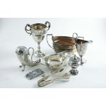 A MIXED LOT:- A horn-shaped sugar caster, a trophy cup, a sauce boat, two pairs of sugar tongs, a