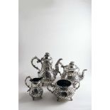 A VICTORIAN FOUR-PIECE TEA & COFFEE SERVICE with embossed baluster bodies, leafy scroll feet and