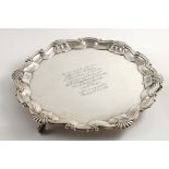 AN EDWARDIAN SALVER of shaped circular outline with a shell and scroll border and ball & claw