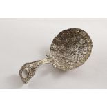 A GEORGE III CADDY SPOON the bifurcated stem with floral decoration and an oval cartouche, the