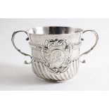 A QUEEN ANNE PORRINGER with twin, beaded s-scroll handles, decorated with embossed wrythen fluting