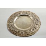A LATE VICTORIAN EMBOSSED CIRCULAR SHALLOW DISH OR PLATE with a broad rim, decorated in relief work,