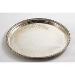 AN EARLY 20TH CENTURY CIRCULAR TRAY with a hammered finish and an applied border of beads &