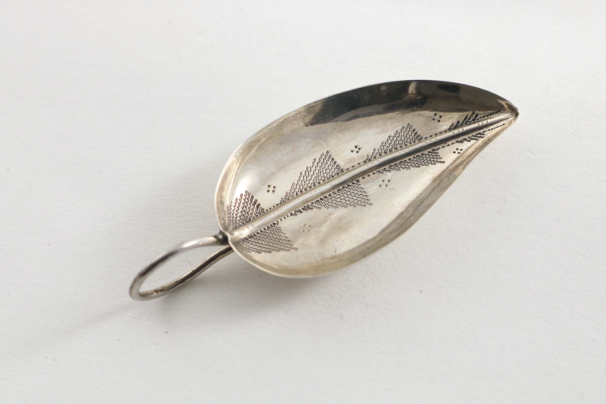 A GEORGE III "LEAF" CADDY SPOON with engraving and a tendril handle, initialled "CE" on the back