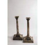 A PAIR OF GEORGE III COLUMN CANDLESTICKS with Corinthian capitals on bevelled square bases,