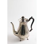 AN EDWARDIAN BALUSTER COFFEE POT with swirl fluting and four legs, and an armorial on one side, by