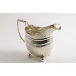 A GEORGE III CREAM JUG on ball feet with engraved borders, initialled by Thomas Watson, Newcastle