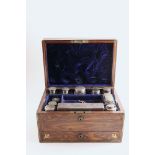 A VICTORIAN BRASS BOUND ROSEWOOD DRESSING CASE fitted with various mounted cut-glass bottles/jars, a