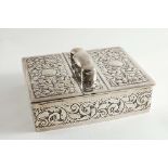 A LATE VICTORIAN RECTANGULAR CIGAR/CIGARETTE BOX with chased scrollwork, a central handle and twin
