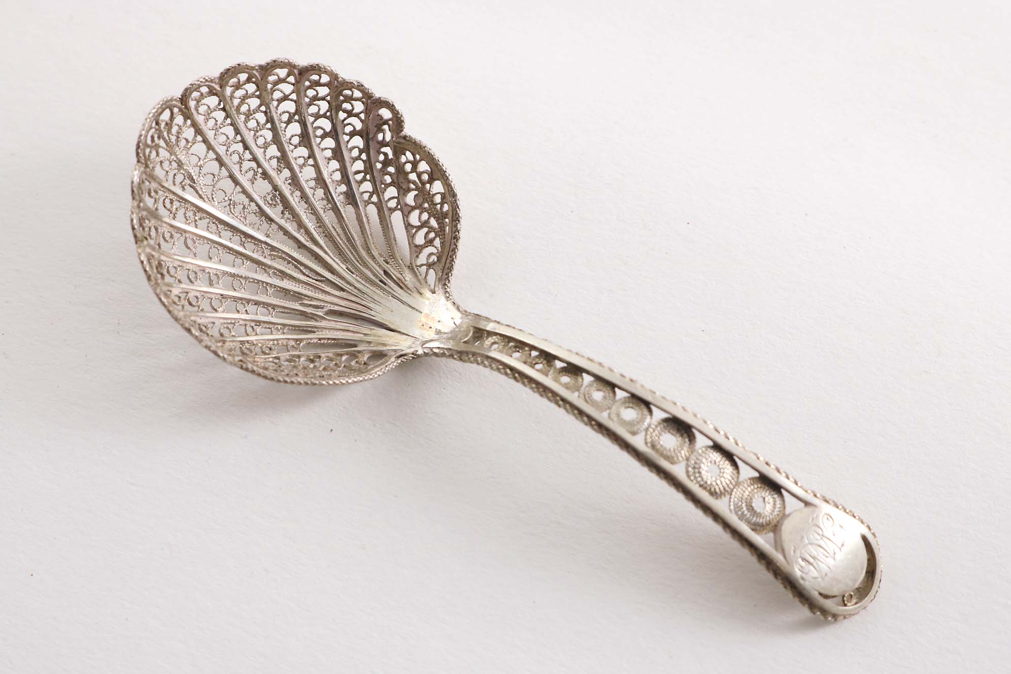 A GEORGE III FILIGREE CADDY SPOON with an initialled oval cartouche at the top of the stem,