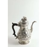 A GEORGE IV IRISH COFFEE POT of baluster form with repousse-work decoration incorporating eagles,