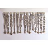 CAST & PIERCED ARMS:- Fourteen various pairs of George III sugar tongs, mixed makers & dates, all
