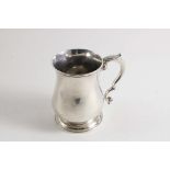 A GEORGE II BALUSTER MUG with a leaf-capped scroll handle & a speeding circular foot, maker's mark