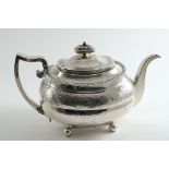 A GEORGE III ENGRAVED TEA POT of rounded oblong form on ball feet, with a low-domed cover, cushion-
