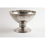AN EDWARDIAN CIRCULAR PEDESTAL BOWL on a spreading foot with a hammered finish and chased linked