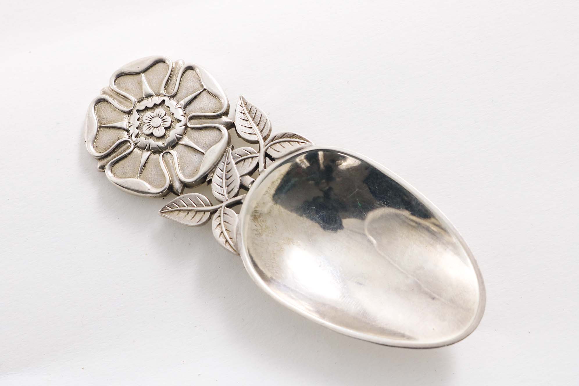 A CONTEMPORARY SCOTTISH CADDY SPOON with a Tudor rose & leaf handle & an egg-shaped bowl, by R.E.