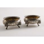 A PAIR OF 19TH CENTURY UNASCRIBED OVAL SALTS with lion mask feet, chased decoration and gilt