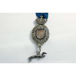 A RARE GEORGE III PARCELGILT KING'S MESSENGER BADGE cast in the form of the Royal strap & buckle