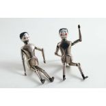 A PAIR OF EDWARDIAN NOVELTY PEPPERETTES each modelled as a miniature, articulated doll, with jointed