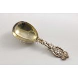A VICTORIAN CADDY SPOON with a gilt bowl and a fruiting vine stem, by Hyam Hyams, London 1872; 4" (