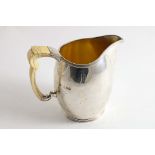 AN EARLY 20TH CENTURY JUG with an oviform body, reeded borders & an ivory handle, gilt interior,