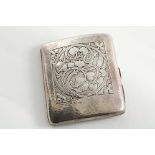 AN EARLY 20TH CENTURY CIGARETTE CASE with a hammered finish and a chased panel of entwined, stylised