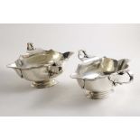 A PAIR OF EARLY 20TH CENTURY DOUBLE-LIPPED SAUCE BOATS on spreading oval bases, with shaped and