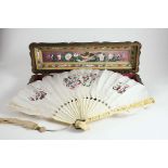 A CANTON IVORY FAN guards deeply carved with figures among buildings, carved and pierced sticks,