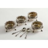 A SET OF FOUR VICTORIAN EMBOSSED CIRCULAR SALTS on three legs, gilt interiors, by Charles Stuart