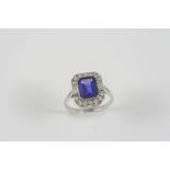 A TANZANITE AND DIAMOND CLUSTER RING the step-cut tanzanite is set within a surround of two