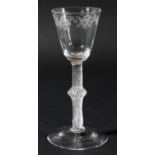 ENGLISH WINE GLASS, circa 1750, the rounded funnel bowl engraved with a border of flowers on a