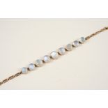 A MOONSTONE AND GOLD BRACELET formed with graduated oval-shaped moonstone cabochons on a gold