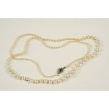 A SINGLE ROW GRADUATED NATURAL PEARL NECKLACE the clasp set with rose-cut diamonds and a green