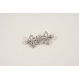 A DIAMOND FOLIATE BROOCH the foliate scrolling mount is set overall with graduated circular-cut