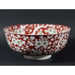 CHINESE IRON RED REVERSE PAINTED BOWL, 20th century, with an all over prunus pattern, blue six