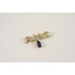 A DIAMOND AND SAPPHIRE BIRD BROOCH formed as two diamond set birds, suspending a pear-shaped