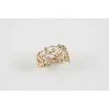 A DIAMOND AND GOLD RING the gold scrolling openwork mount is set with circular-cut diamonds. Size
